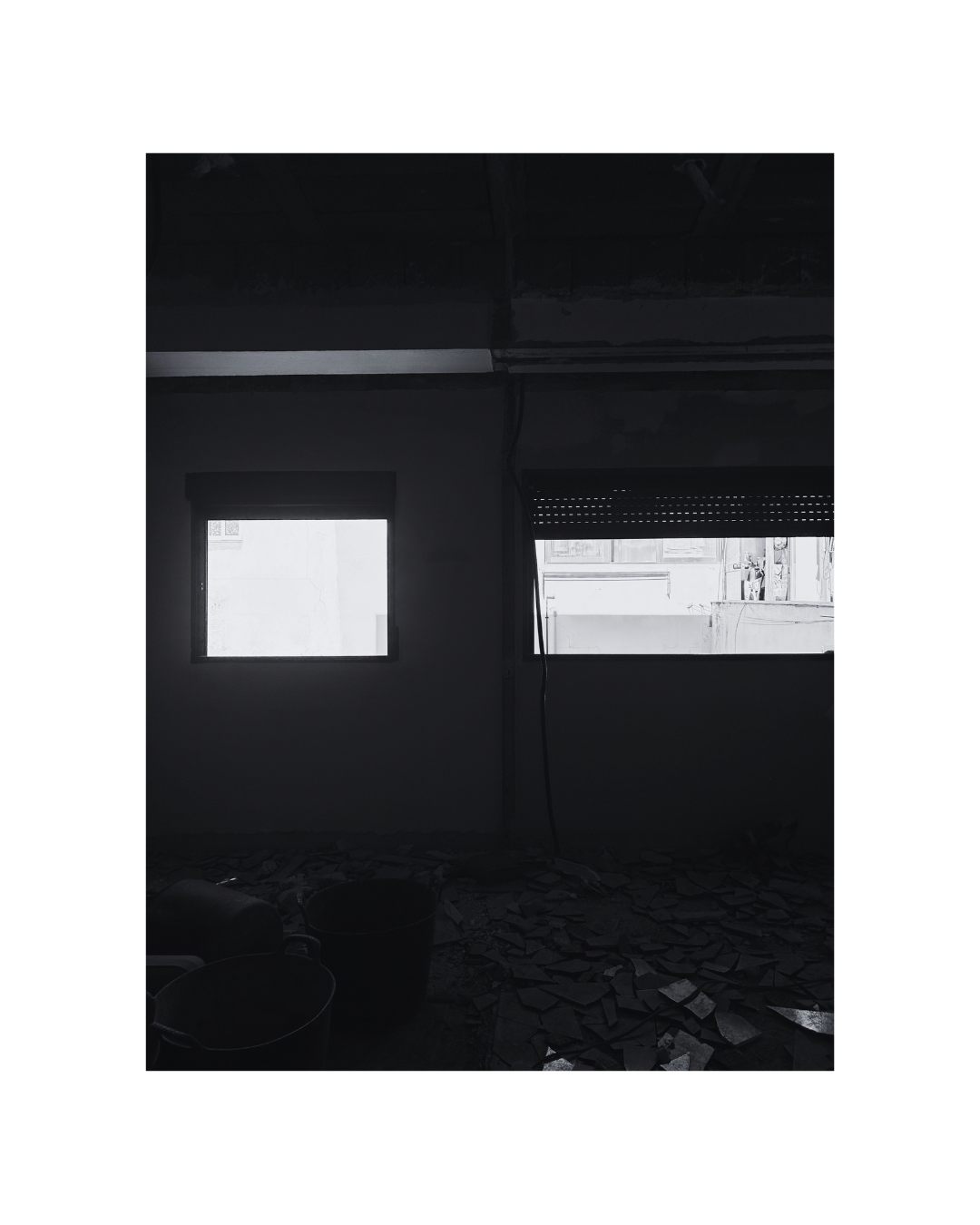 Interior en obra con dos ventanas, en blanco y negro